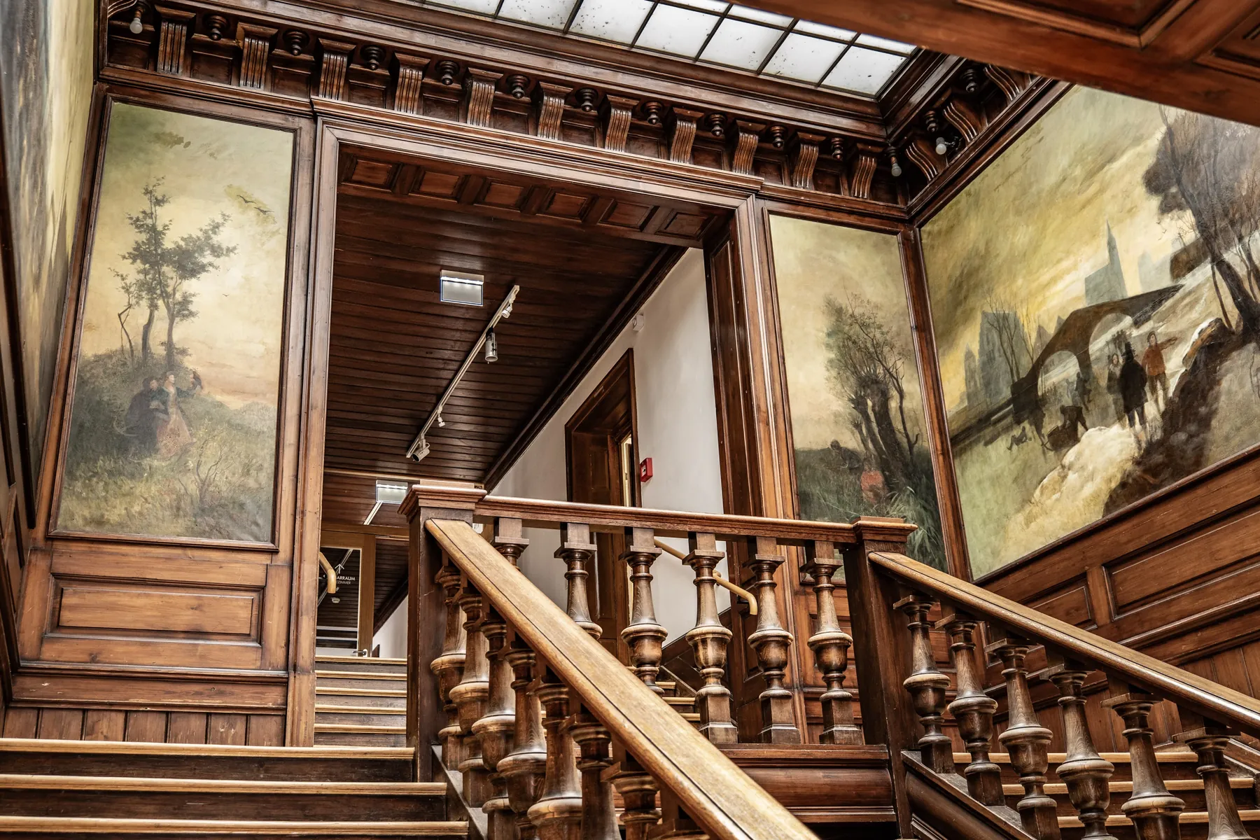 Historisches Treppenhaus mit Holzbalustrade und Wandmalereien
